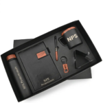 6-piece black and wood-grain executive corporate gift set in a presentation box featuring a flask, notebook, pen, mug, keychain, and phone stand.