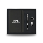 Black 3-piece custom corporate gift set inside a presentation box, featuring a branded notebook, pen, and keyring