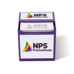 Purple custom memo cube holder displaying a colourful promotional logo on its front panel and top flap, filled with branded note paper.